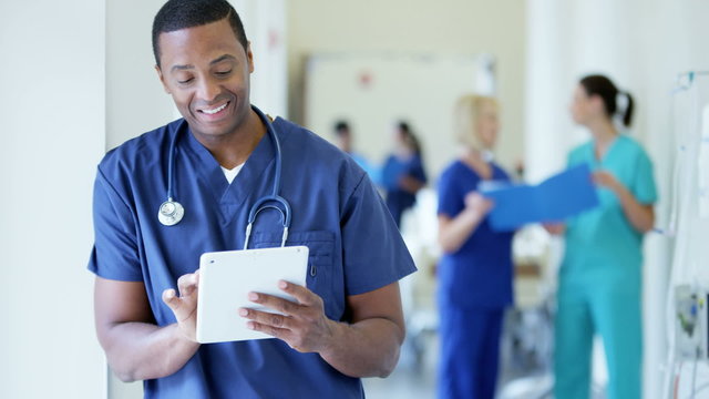 Portrait of African American male staff working on tablet technology in hospital