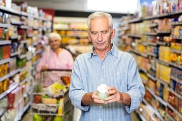 Senior man looking at canned food