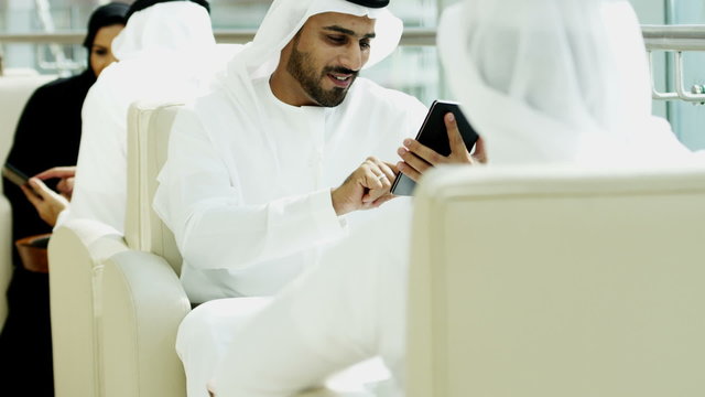 Emirati male female business colleagues meeting oil commodity tablet technology