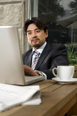 Businessman Using Laptop At Cafe