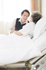 Senior man taking care of wife in hospital