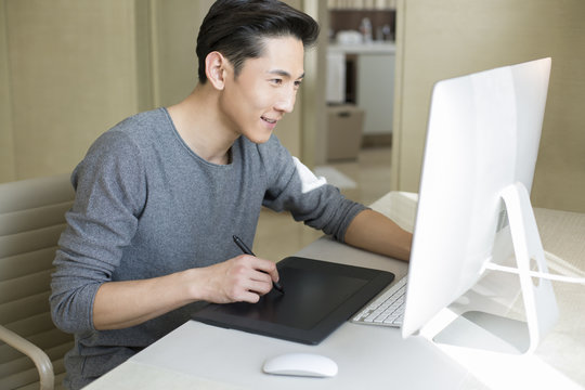 Young male fashion designer working at home