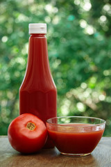 Tomato, glass bowl and bottle of ketchup