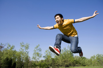 Young man jumping in air at park