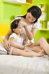 Mother putting her hand on sick daughter's forehead