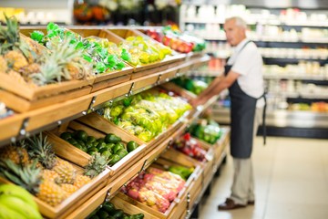 Senior male worker stocking the vegetables 