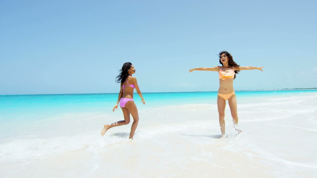 Young multi ethnic girlfriends wearing a bikini on beach