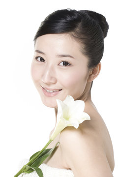 Beauty shot of a young woman with a Lily flower