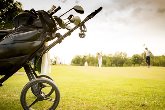 Golf bag with clubs on green field