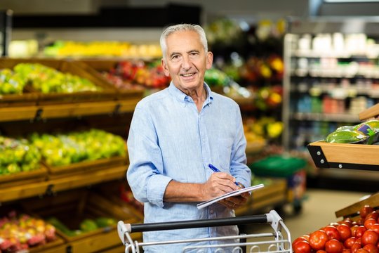Smiling senior man with grocery list 