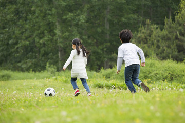 Happy children playing football together