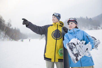 Young couple with snowboards on the snow