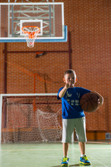Fototapeta premium Proud little boy holding a basketball