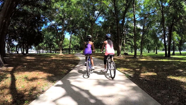 Young active multi ethnic girls riding bikes in park