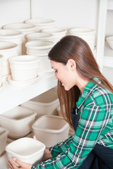 Obraz na płótnie Canvas Woman working in a ceramics shop