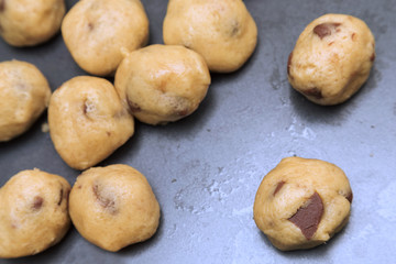 raw chocolate cookie dough on tin baking tray, selective focus