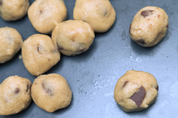 raw chocolate cookie dough on tin baking tray, selective focus