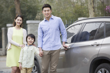 Happy young family and car