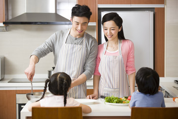 Happy young family cooking in kitchen
