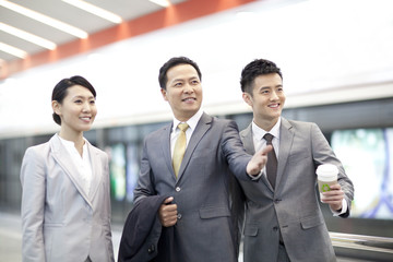 Cheerful business people at subway station © Blue Jean Images