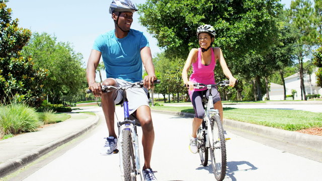 Young active African American couple cycling outdoor