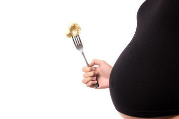 Pregnant woman is eating a cauliflower