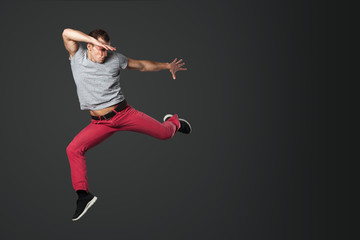 Obraz na płótnie Canvas Young male dancer jumping in studio.
