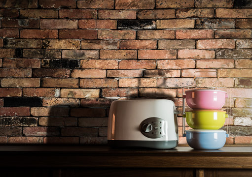 Colorful tiffin carrier and toaster on wooden cupboard with vint