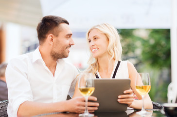happy couple with tablet pc at restaurant lounge