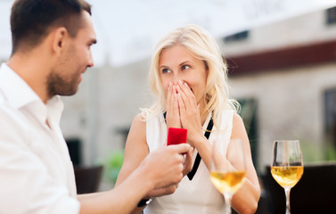 happy couple with engagement ring and wine at cafe