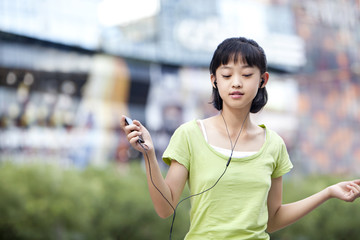 Cool schoolgirl listening to MP3 player