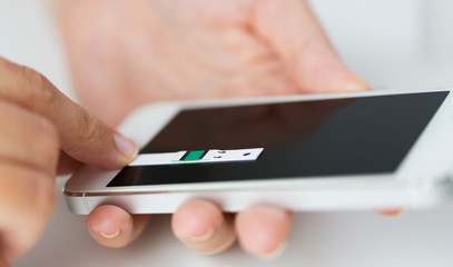 close up of woman with smartphone doing blood test