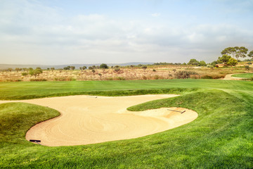 Sand trap and bunker near a golf green