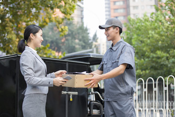 Young woman getting a package from delivery person