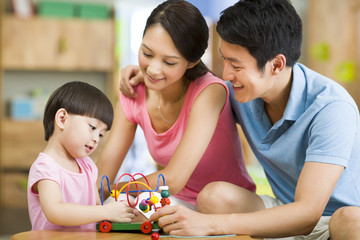 Little girl playing with toys at home