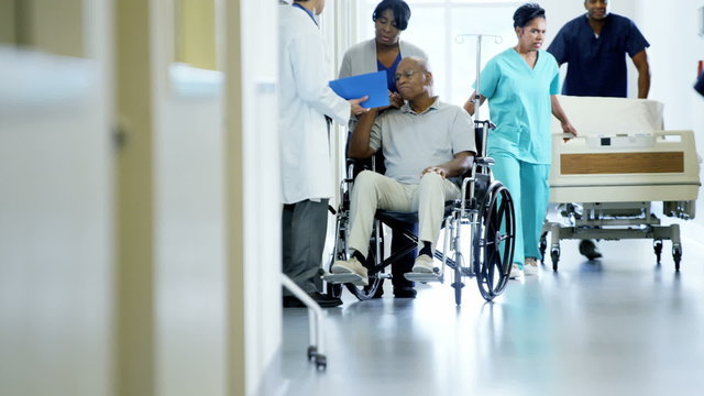 African American disability senior male on wheelchair and wife in hospital