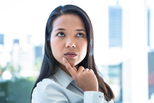 Thoughtful businesswoman with finger on chin