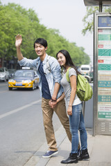 Young couple waiting at the bus stop © Blue Jean Images