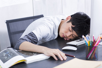 Fototapeta premium Young man taking a nap in the office