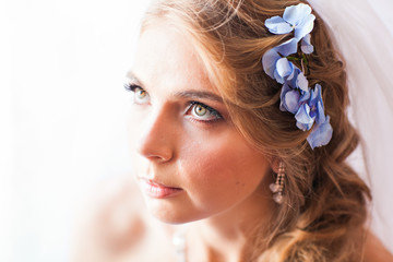 Naklejka premium Portrait of beautiful young woman with flowers in hair. Make up and hair style. 