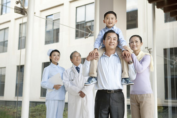 Obraz premium Young Family Stands in a Hospital Corridor With a Doctor and a Nurse