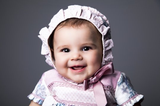 Beb&eacute; con gorrito y lazo sonriendo