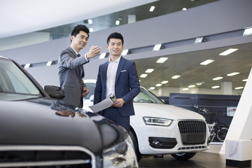 Fototapeta na wymiar Young businessman choosing car in showroom