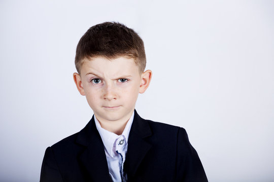 Funny emotion of  little boy young man with a raised eyebrow wearing costume with braces.Happy little boy over white background.Smiling, Happy, Joyful beautiful little boy , looking at camera.