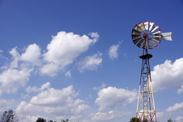 tall old metal windmill in blue sky © stephaniemurton