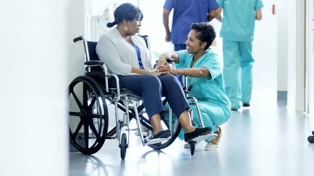 African American female doctor and patient on wheelchair consult in hospital 