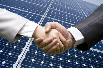 Handshake in front of solar panels