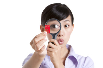 Woman Looking at a Chinese New Year Envelope Through a Magnifying Glass