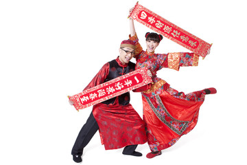 Humorous couple in traditional Chinese clothing holding Chinese couplet