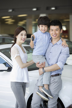 Young family buying car in showroom